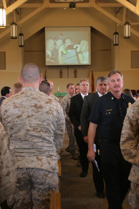 060127-M-7082F-003 CAMP PENDLETON, Calif. -- All  who have come to pay their respects to Sgt. Adam Cann at his memorial service here Jan. 27 file out of the chapel as a slide show featuring pictures of Cann growing up plays. Cann, from Destin, Fla., was killed in action Jan. 5 while conducting crowd control with his dog Bruno during his second deployment to Iraq. (Official U.S. Marine Corps photo by Lance Cpl. Patrick J. Floto)(released)