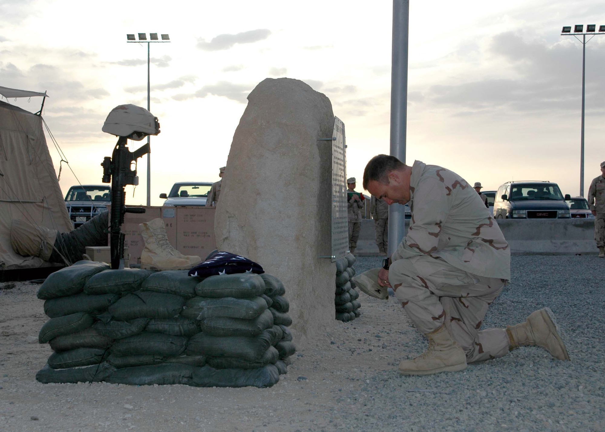 SOUTHWEST ASIA -- Col. Tim Hale prays for two fallen Airmen during a memorial retreat here Jan. 27. More than 500 people attended the retreat ceremony which honored Tech. Sgt. Jason Norton and Staff Sgt. Brian McElroy. The Airmen were killed in Iraq by an improvised explosive device. (U.S. Air Force photo by Staff Sgt. Patricia Findley) 