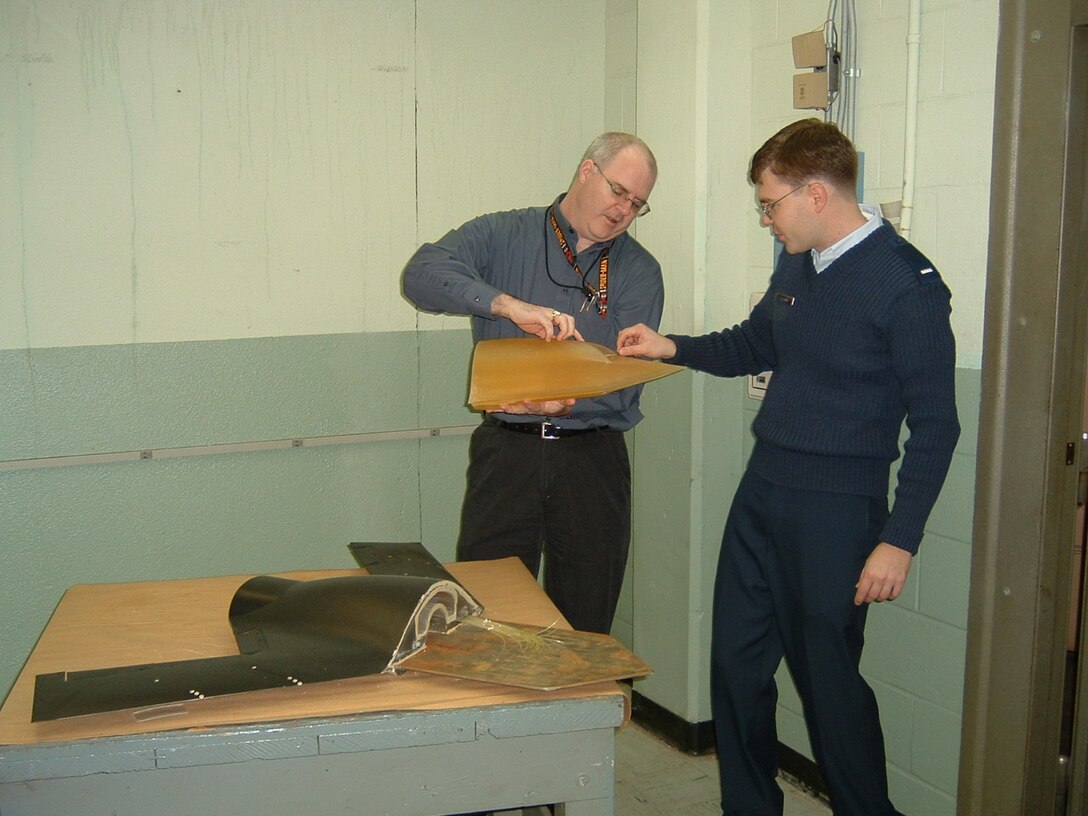 Dr. Charles Tyler (left) and 1st Lt. Erik Saladin examine an X-45A Unmanned Combat Air Vehicle model created using rapid prototyping technology.  (Air Force photo by Melissa Withrow)

