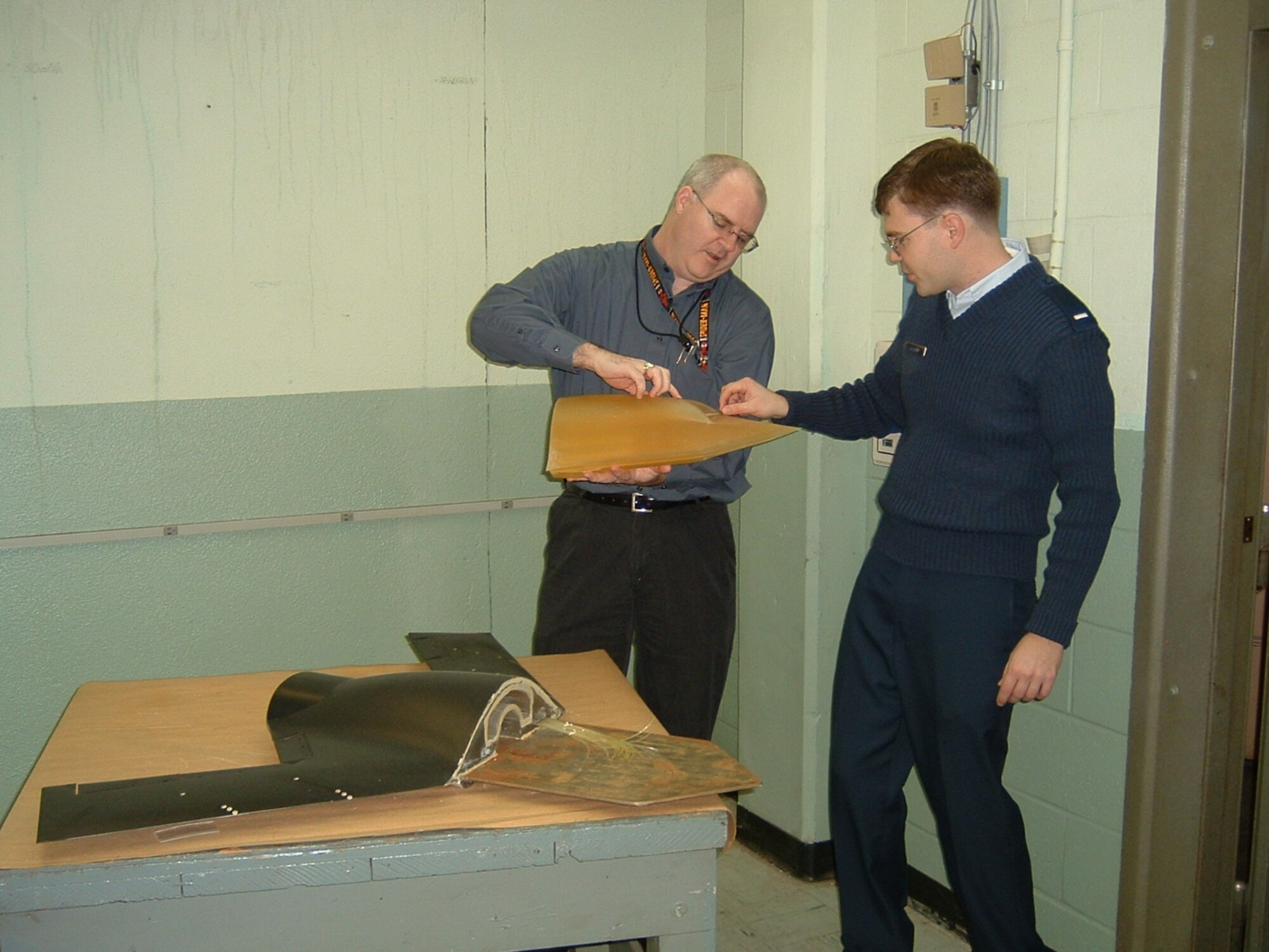 Dr. Charles Tyler (left) and 1st Lt. Erik Saladin examine an X-45A Unmanned Combat Air Vehicle model created using rapid prototyping technology.  (Air Force photo by Melissa Withrow)

