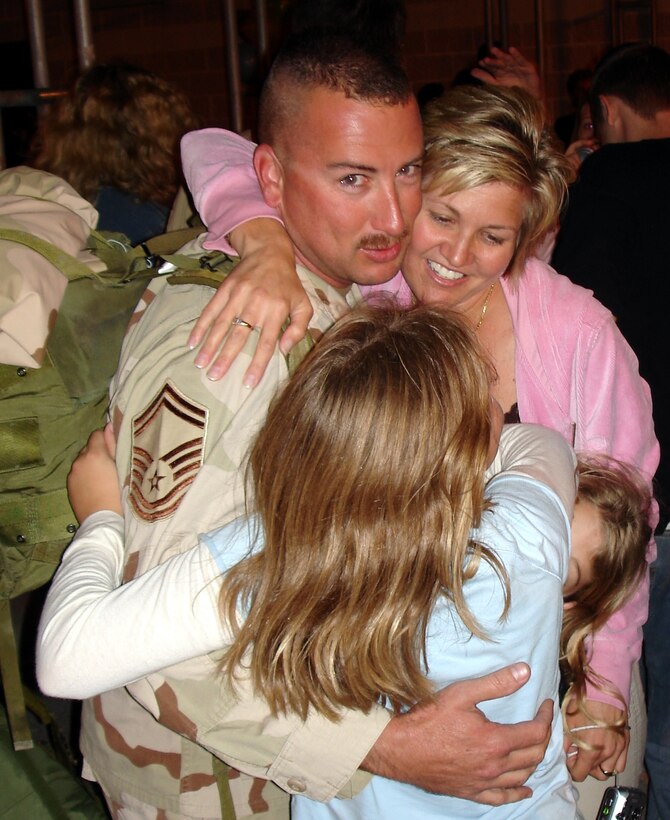 Senior Master Sgt. Michael Metzger, 482nd Maintenance Group, reunites with his wife, Connie, and his two daughters upon returning from Balad Air Base, Iraq on Friday evening, Jan. 20.  About 40 HARB Reservists returned after spending up to 120 days supporting Operation Iraqi Freedom. After leaving Iraq, they traveled through the Middle East, Germany, Iceland and Boston, Mass before arriving back at Homestead ARB (U.S. Air Force Reserve photo by Jake Shaw).