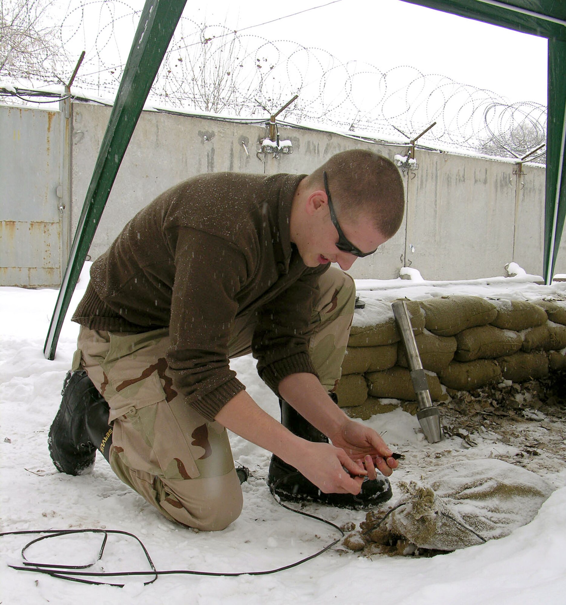 MANAS AIR BASE, Kyrgyzstan (AFPN) -- Senior Airman Robin Cunningham checks the wiring before detonating a charge during explosive tool training here.  Airman Cunningham is an explosive ordnance technician with the 376th Civil Engineer Squadron, Explosive Ordnance Disposal flight. He is deployed from Whiteman Air Force Base, Mo. (U.S. Air Force photo by Capt. James Bressendorff)
