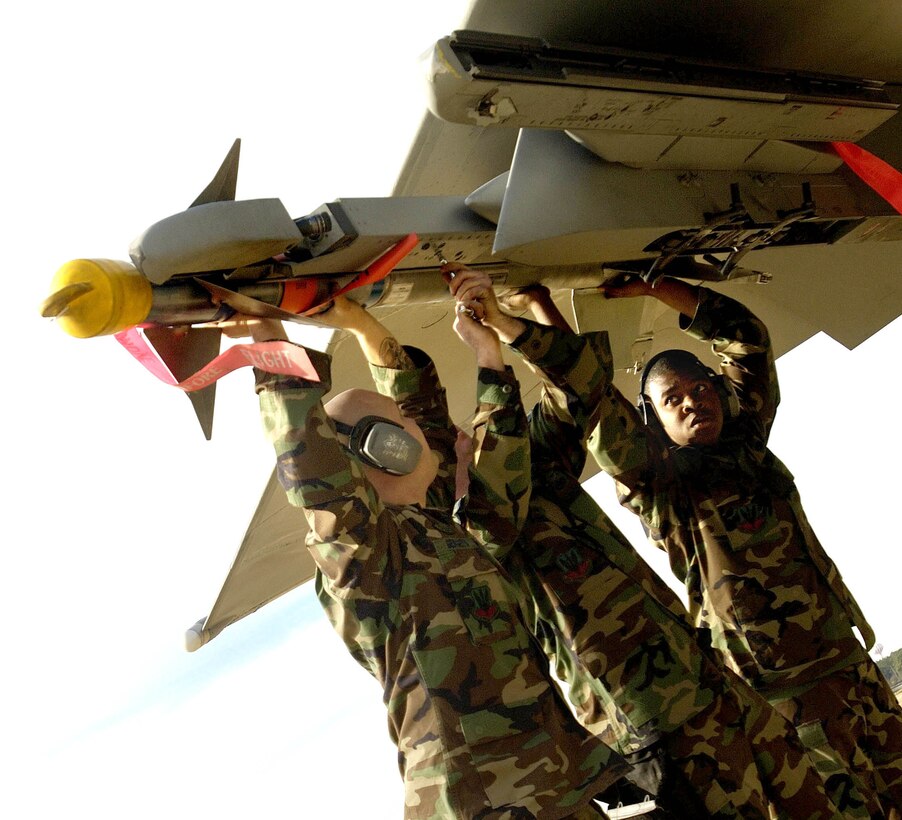 LANGLEY AIR FORCE BASE, Va. (AFPN) - (Left to right) Staff Sgt. Jason Larkins, and Senior Airmen Michael Gergets and Aaron Scott secure an AIM-9 missile to an F-15 Eagle during the load crew of the year event here in January.  The event was part of the 1st Fighter Wing annual load competition and was the first one to include the F-22A Raptor.  The 71st Fighter Squadron won the event. The Airmen are assigned to the 71st's aircraft maintenance unit. (U.S. Air Force photo by Senior Airman Austin Knox)