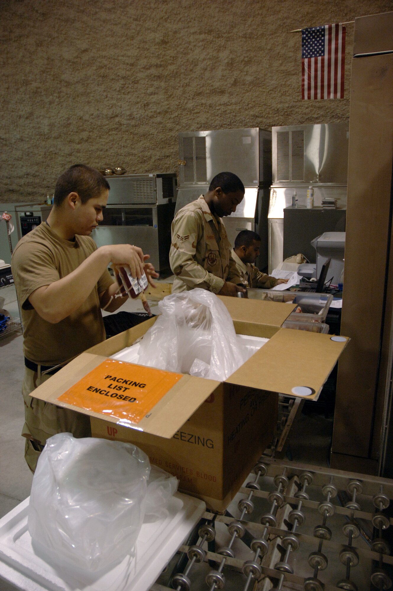 SOUTHWEST ASIA (AFPN) -- Senior Airman Jesus Herrera (left), Airman 1st Class Roaquiem Manderson (center) and Staff Sgt. Ronell Ramcharitar unload blood samples for inventory at the blood transshipment center here Jan. 28. The center gets blood from the United States and sends it throughout the region. Airman Menderson and Sergeant Ramcharitar are deployed from Langley Air Force Base, Va. Airman Herrera is deployed from Travis AFB, Calif.  The Airmen are with the 379th Expeditionary Medical Support Flight.  (U.S. Air Force photo by Staff Sgt. Joshua Strang)