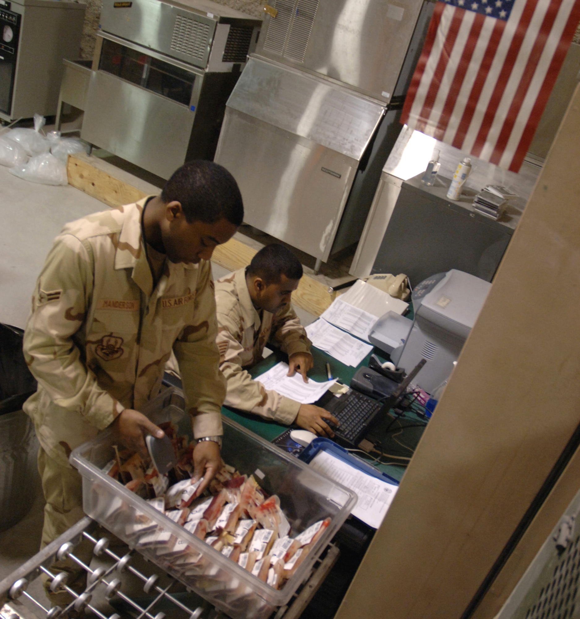 SOUTHWEST ASIA (AFPN) -- Airman 1st Class Roaquiem Manderson (left) and Staff Sgt. Ronell Ramcharitar unload blood samples at the blood transshipment center here Jan. 28. The center gets blood from the United States and sends it throughout the region. Both Airmen are with the 379th Expeditionary Medical Support Flight and deployed from Langley Air Force Base, Va.  (U.S. Air Force photo by Staff Sgt. Joshua Strang) 