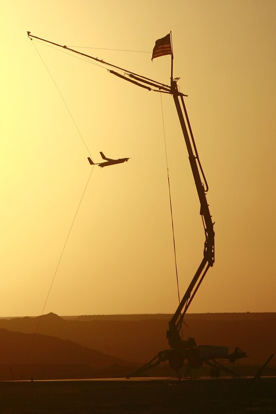 A ScanEagle's wing clips the wire on the 50-foot-tall "Skyhook" system in the Al Anbar Province of Iraq, Aug. 31. The "Skyhook" system is designed to catch the ScanEagle from flight, as the aircraft has a hook on its wingtip to snag the wire after making contact with it.