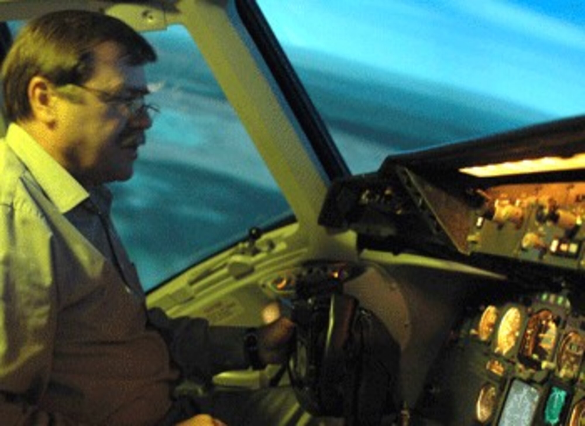Mr. Steve Andrews, KC-10 Aircrew Training System Site Manager, banks left in the KC-10 flight simulator.  It has a wide screen wrap around visual system that displays a realistic view out of the windows.