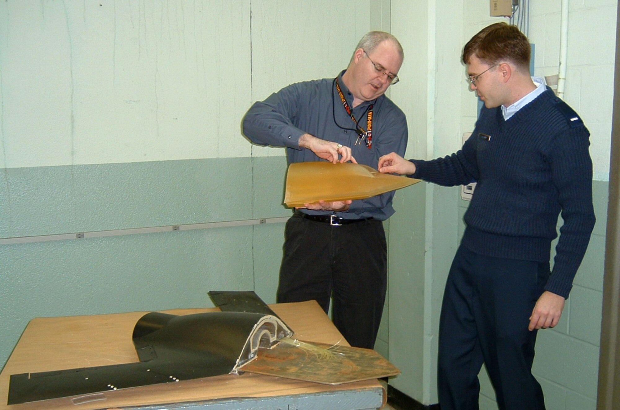 WRIGHT-PATTERSON AIR FORCE BASE, Ohio (AFPN) -- Dr. Charles Tyler (left) and 1st Lt. Erik Saladin examine an X-45A unmanned combat air vehicle model created using rapid prototyping technology. (U.S. Air Force photo by Melissa Withrow) 
