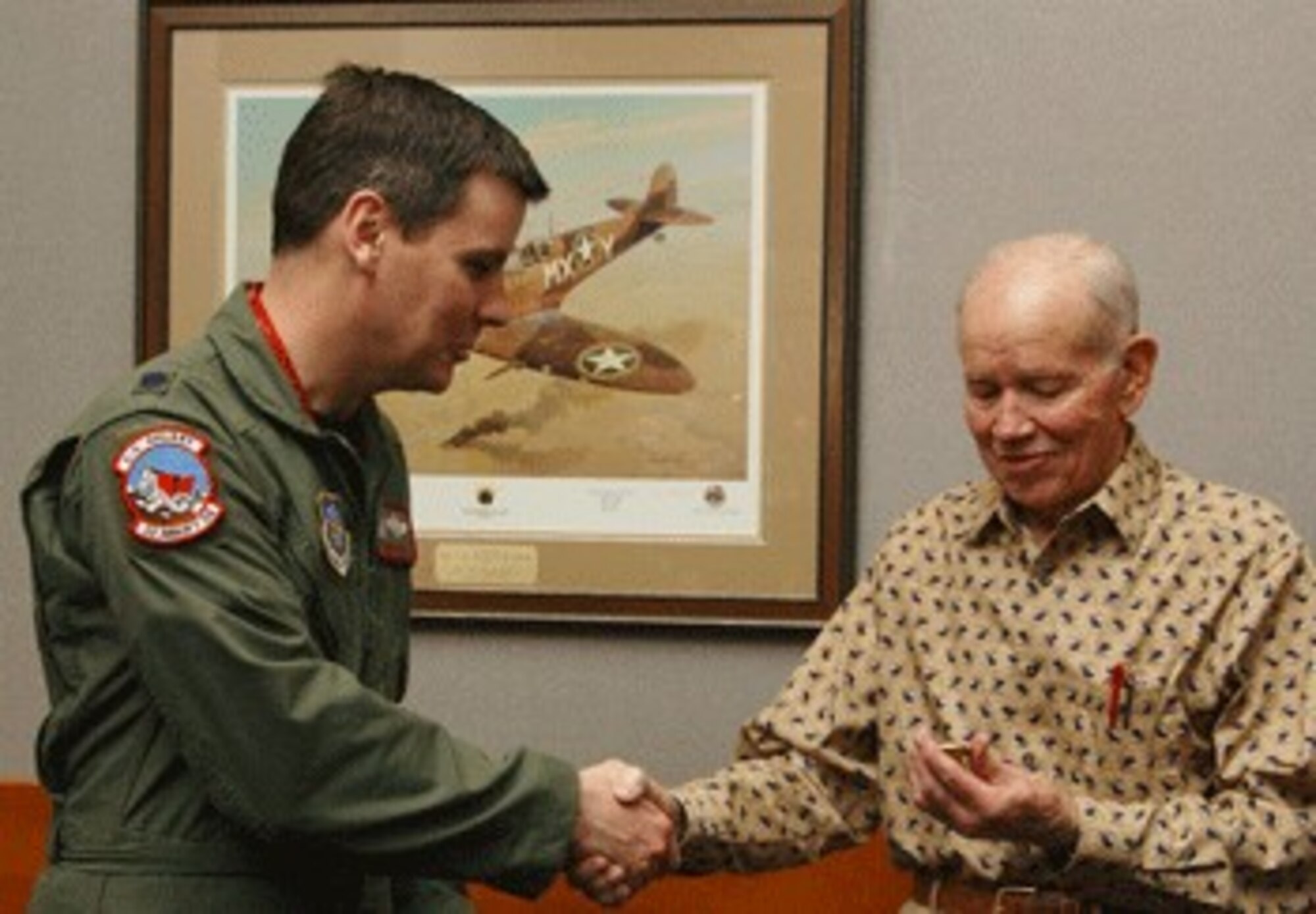 Lt. Col. John Payne, 22nd Airlift Squadron commander, thanks Mr. J.D. Collinsworth, a fighter ace who served in World War II. The 22nd Airlift Squadron honored retired Col. Collinsworth’s place in Air Force history Dec. 21.