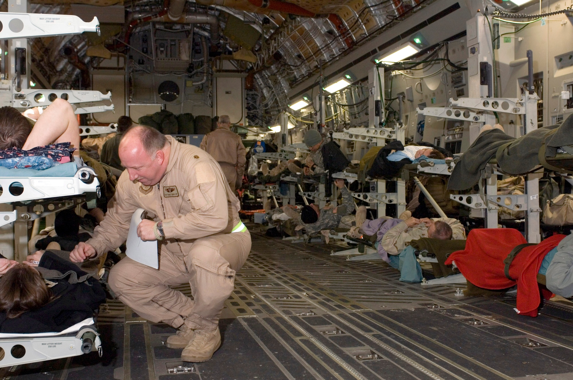 OVER IRAQ -- Maj. Ken Winslow talks with a patient on a C-17 Globemaster III.  Major Winslow is a Reservist from McChord Air Force Base, Wash deployed with the 791st Expeditionary Aeromedical Evacuation Squadron.   The 791st transports servicemembers to health-care facilities in Germany and the U.S.  (U.S. Air Force photo by Master Sgt. John E. Lasky)