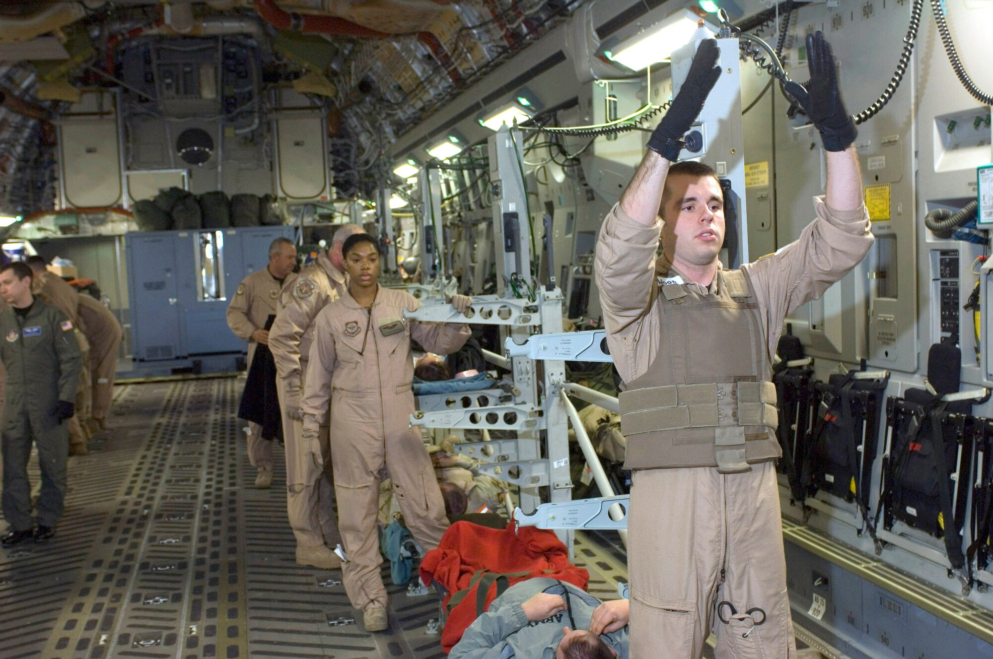 BALAD AIR BASE, Iraq (AFPN) -- Staff Sgt. Natalie Stockhausen waits for the next patient litter as Senior Airman Daniel Wood guides it onto a C-17 Globemaster III.  Both Reserve medics are with the 791st Expeditionary Aeromedical Evacuation Squadron.  They move patients to health-care facilities in Germany and the U.S.  Airman Wood is deployed from the 94th Aeromedical Evacuation Squadron at Dobbins Air Force Base, Ga., and Sergeant Stockhausen is deployed from the 446th AES at McChord AFB, Wash.  (U.S. Air Force photo by Master Sgt. John E. Lasky)