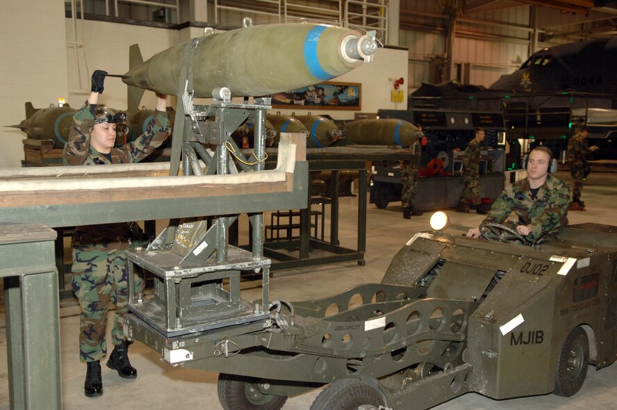 MINOT AIR FORCE BASE, N.D. (AFPN) -- Senior Airmen Stephanie Lopez and Nathon Bowling load a bomb onto an MJ-1 jammer during a load crew competition here Jan. 27.  The crews loaded nine Mk-82 500-pound general purpose bombs onto a B-52H Stratofortess. The four-person crews were graded on teamwork, safety, precision and speed.  Both Airmen are weapons loaders assigned to the 5th Aircraft Maintenance Squadron.  (U.S. Air Force photo by Airman 1st Class Christopher Boitz)