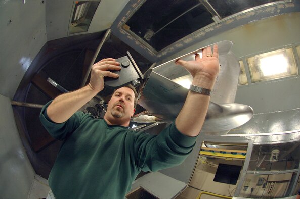 LANGLEY AIR FORCE BASE, Va. (AFPN) -- Earl Harris adjusts the wing fold of the aerial regional-scale environmental survey of Mars airplane in the NASA 12-foot low-speed tunnel here.  The tunnel will test the airplane for stability in various wind conditions and validate its aerodynamics. Mr. Harris is a mechanical engineering technician with the National Aeronautics and Space Administration. (U.S Air Force photo by Staff Sgt. Eric T. Sheler)