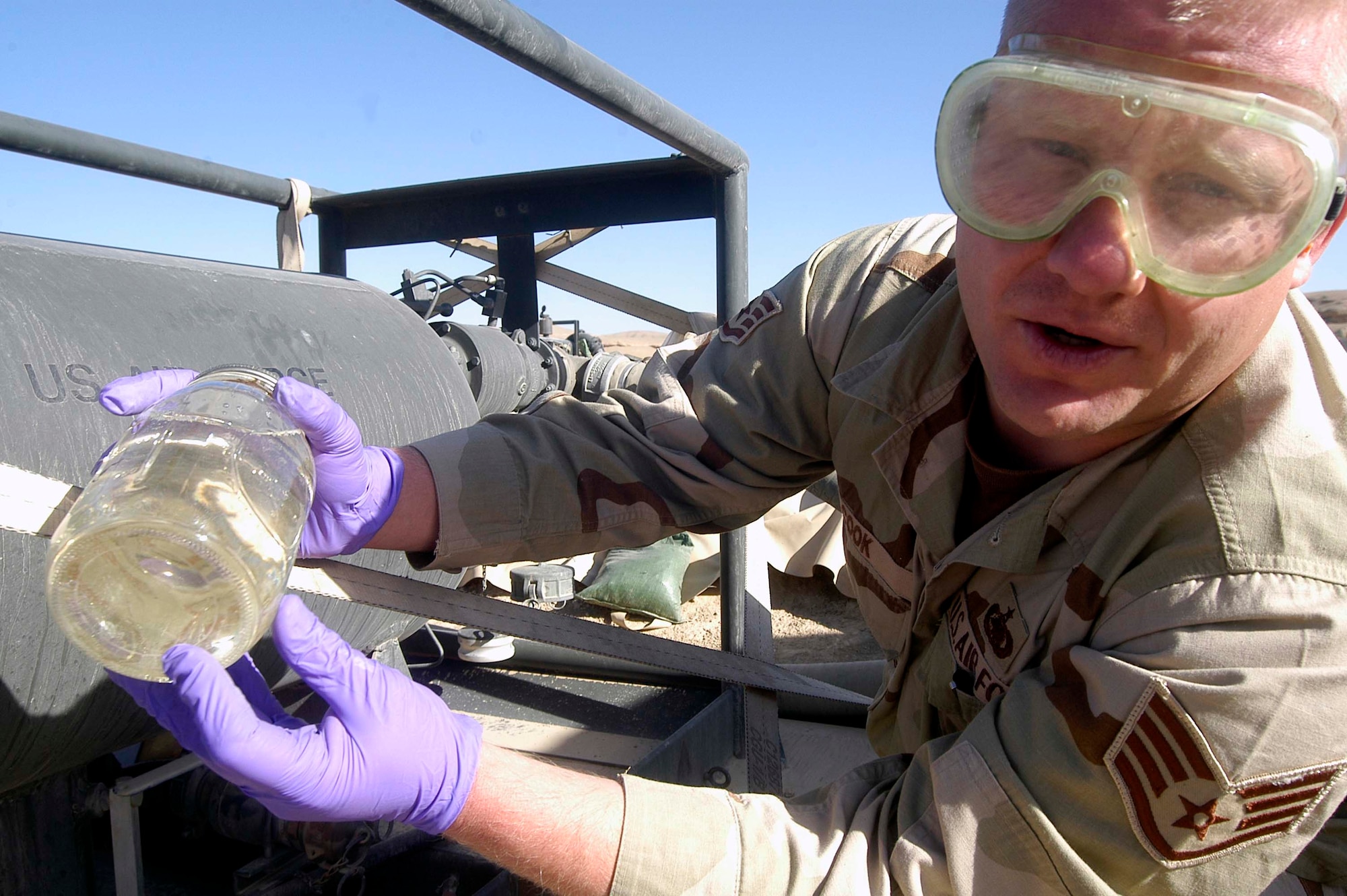 Staff Sgt. William Cook checks a fuel sample he has collected from an R-22 fuel pumping unit at Chaghcharan Forward-Operating Base, Afghanistan, to make sure it has the proper color, clarity, as well as free of water and particulates.  Sergeant Cook is one of four Airmen deployed to Chaghcharan, which is run by the Lithuanian military and conducts International Security and Assistance Force missions from the base. (US Air Force photo/Maj. David Kurle)
