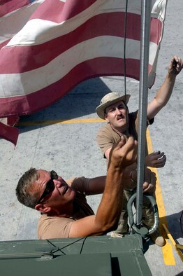 BAGRAM AIRFIELD, Afghanistan -- Tech. Sgt. Paul Hanson and Tech. Sgt. David Steidley raise a 13-star American flag above the flightline here June 26.  The flag has been in the possesion of Sergeant Hanson since 1976 and is now on its fourth deployment with members of the 442nd Fighter Wing.  Both sergeants are Air Force Reservists deployed from the 442nd FW at Whiteman Air Force Base, Mo, and are both avionics technicians.  (US Air Force photo/Maj. David Kurle)
