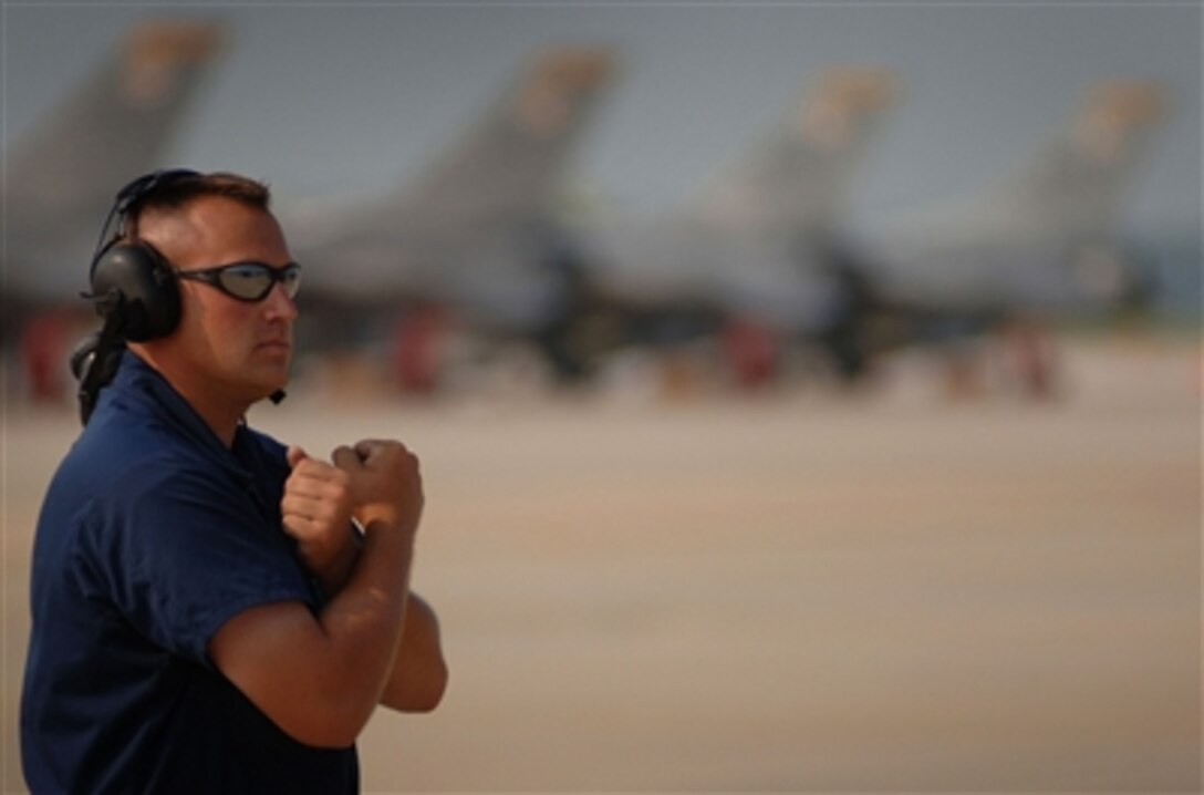 U.S. Air Force Staff Sgt. Brian Gaylor prepares to marshal an F-16 aircraft at Shaw Air Force Base, S.C., June 29, 2006, during exercise Operation Dynamic Weasel. The exercise, which consists of aircraft multiple bases, is designed to sharpen tactics, techniques and procedural skills while practicing for combat situations. Gaylor is assigned to the 77th Fighter Squadron.