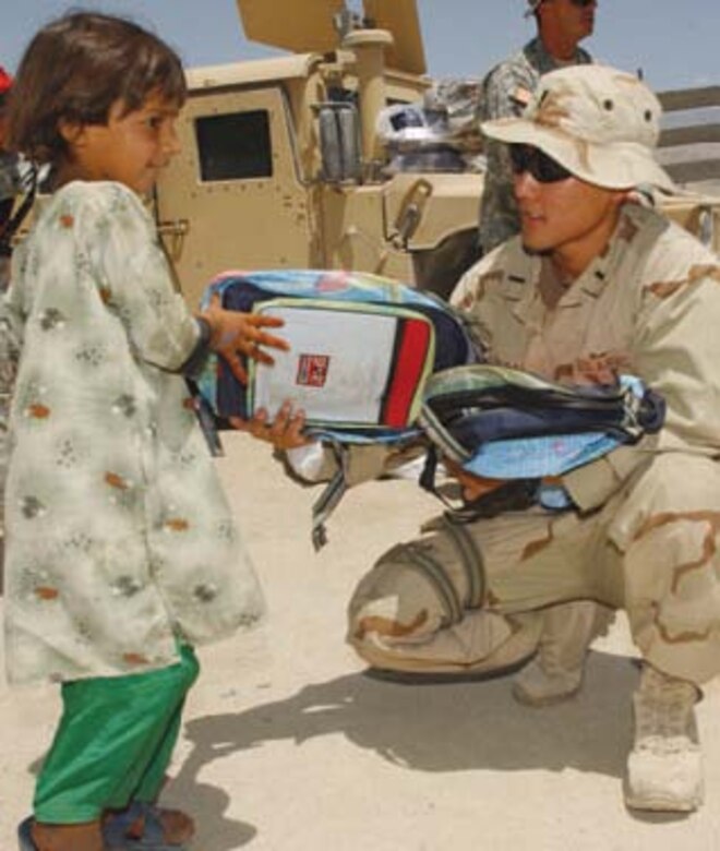1st Lt. Mark Sakai, 3rd Civil Engineer Squadron, hands out humanitarian supplies during a visit with local villagers at Ali Keyhl, Afghanistan May 26. Lt. Sakai, an engineer deployed from Elmendorf in support of Operation Enduring Freedom, is serving a one-year tour with the Provincial Reconstruction Team at Mehtar Lam in eastern Afghanistan.