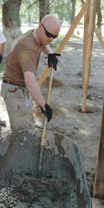 Tech. Sgt. Billy Bowman, 376th Civil Engineer Squadron, deployed from Elmendorf, prepares cement for the new Oktobersky Village School #1 children’s playground at Manas Air Base, Kyrgyzstan.