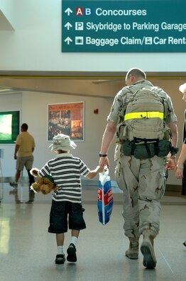 Sergeant Rumler and his son head for baggage claim before heading home. They were among 12 security forces Airmen returning Saturday. The group was greeted by family, squadron members and the 92nd Mission Support Group commander, Col. Van Fuller, the 92nd Security Forces Squadron commander, Maj. Philip Holmes, and first sergeant, Master Sgt. John Bell. 