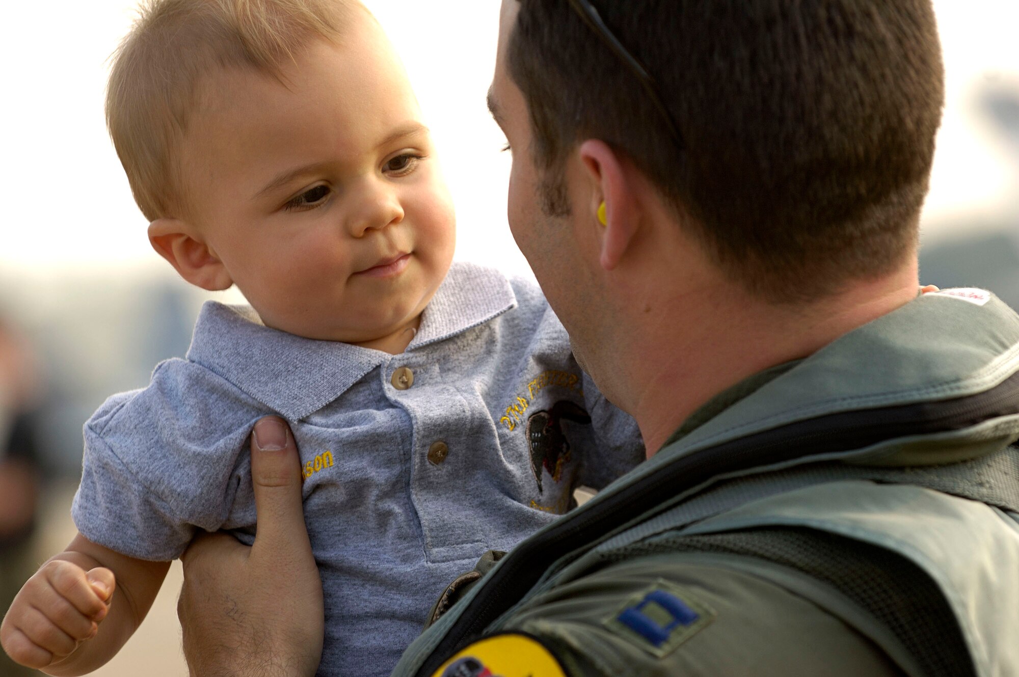 Capt. John Echols shares a moment with his son, Jackson, after arriving at Naval Air Station Oceana, Va., on Friday, June 30. The 27th Fighter Squadron, along with the 71st and 94th FS from Langley Air Force Base, Va., are flying sorties from other installations because of runway repairs at their home station. Captain Echols, who just returned from Elmendorf AFB, Alaska, is an F-22 Raptor pilot assigned to the 27th FS. (U.S. Air Force photo/Staff Sgt. Samuel Rogers)