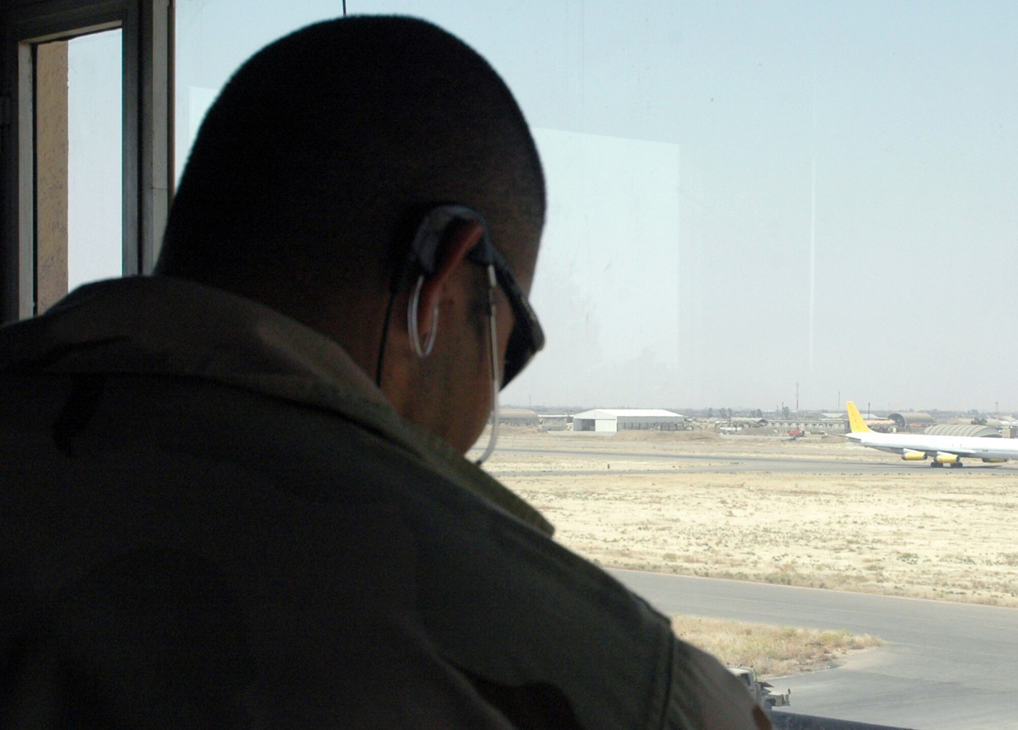 Senior Airman Adam Guerrero watches a cargo plane take off at Kirkuk Air Base, Iraq, on Monday, June 26. He is an air traffic control technician with the 506th Expeditionary Operations Support Squadron. (U.S. Air Force photo/Staff Sgt. Stacy Fowler) 
