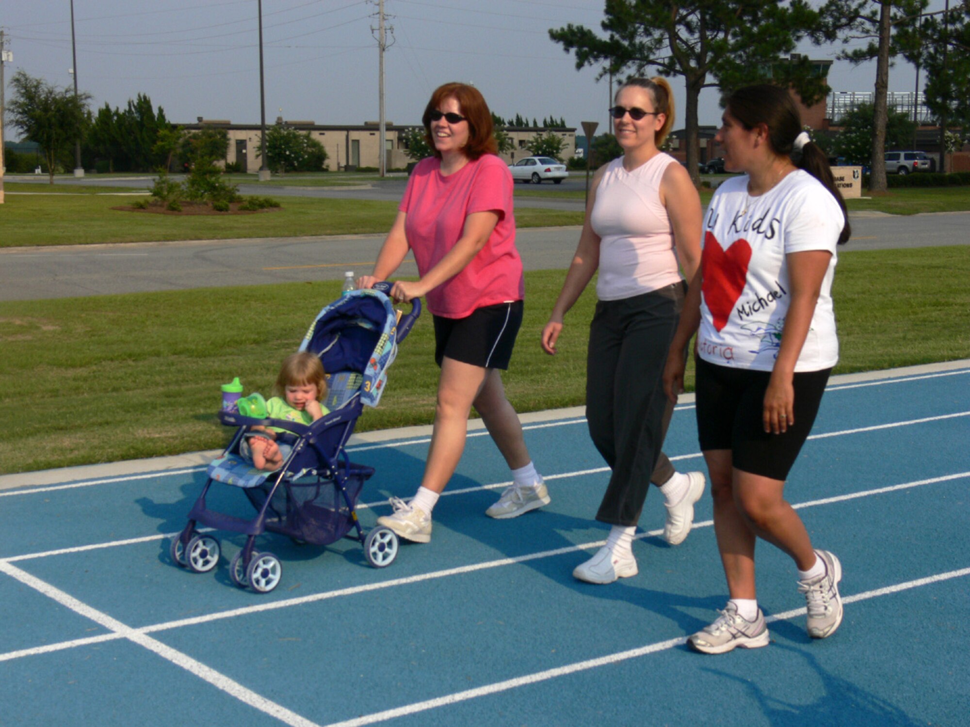 Ginger Smith and her daughter Ainsley, Michelle Palmer and Angelina Knight share their day's stories as they walk around the track at Moody Air Force Base, Ga., on Friday, June 30. They are walking as part of the Inching Toward Iraq program, which focuses the families on walking the distance it would take them to re-unite with their loved ones to help cope with the stress of deployments. Their husbands are deployed with the 823rd Security Forces Squadron. (U.S. Air Force photo/Senior Airman S.I. Fielder)