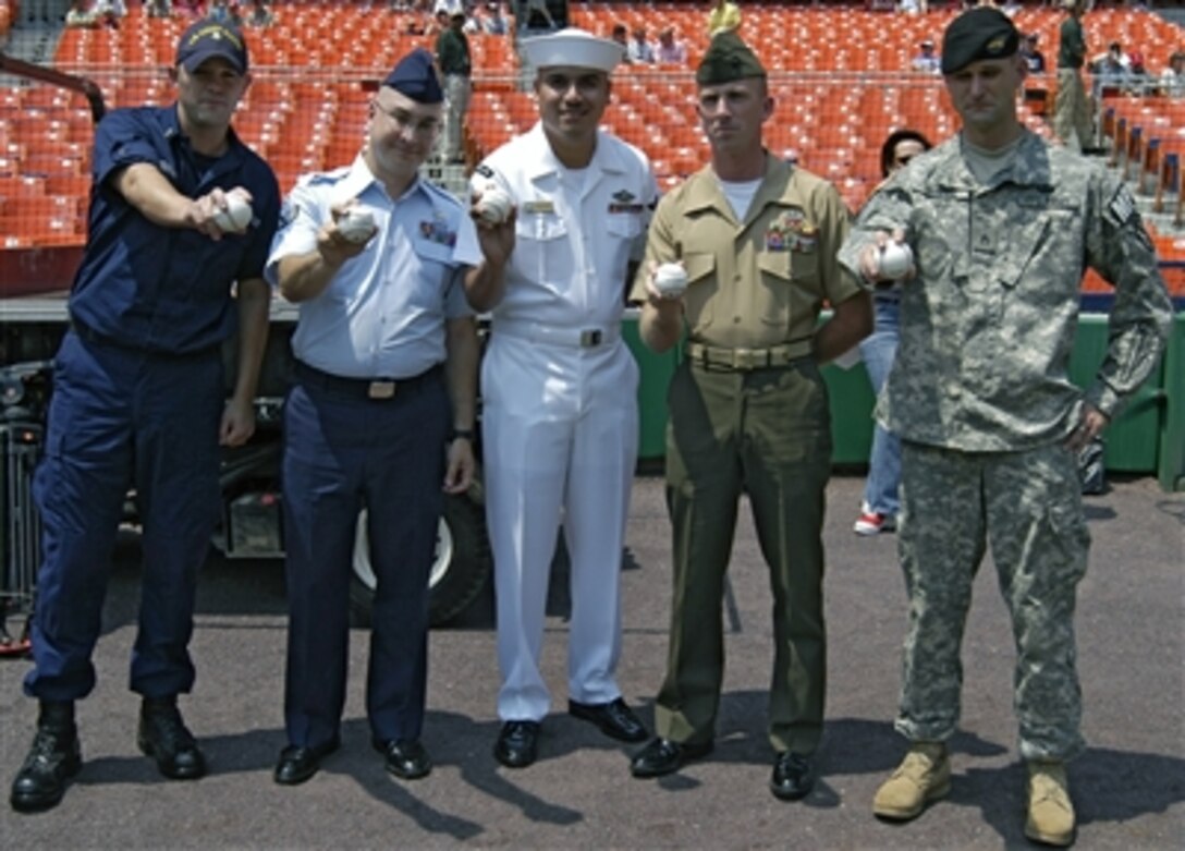 Servicemembers recently back from tours in Iraq and Afghanistan - U.S. Coast Guard Petty Officer 2nd Class Seth Cockran, U.S. Air Force Senior Airman Joseph G. Buzanowski, U.S. Navy Petty Officer 2nd Class Roberto Medrano, U.S. Marine Corps 1st Sgt. Bobby Barnett and U.S. Army Staff Sgt. Jody Belzer - threw a ball from the pitcher's mound during Armed Forces Appreciation Day at RFK Stadium in Washington, July 2, 2006.