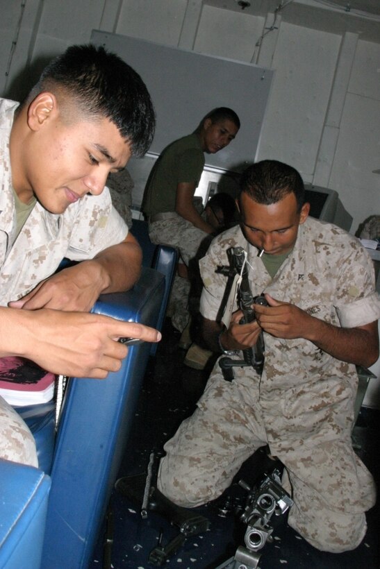 Lance Cpl. Higinio Reyes, Squad Automatic Weapon gunner, 2nd squad, 3rd platoon, times Lance Cpl. Carlos Raices, mortarman gunner, 2nd squad, weapons platoon, to see how fast he can disassemble and re-assemble a 24OG Medium Machine Gun. Marines from Company B, Battalion Landing Team 1st Battalion, 4th Marine Regiment, 11th Marine Expeditionary Unit (Special Operations Capable), Camp Pendleton, Calif., are conducting a Machine Gunners Course here.