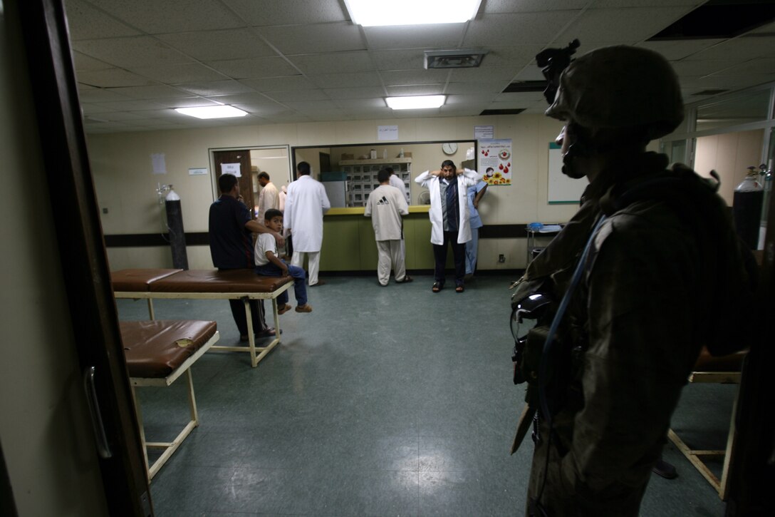 A Marine looks on as the doctors in the Al Ramadi hospital continue on with their day, even though Marines, soldiers and the Iraqi Army were busy securing the hospital from insurgents.