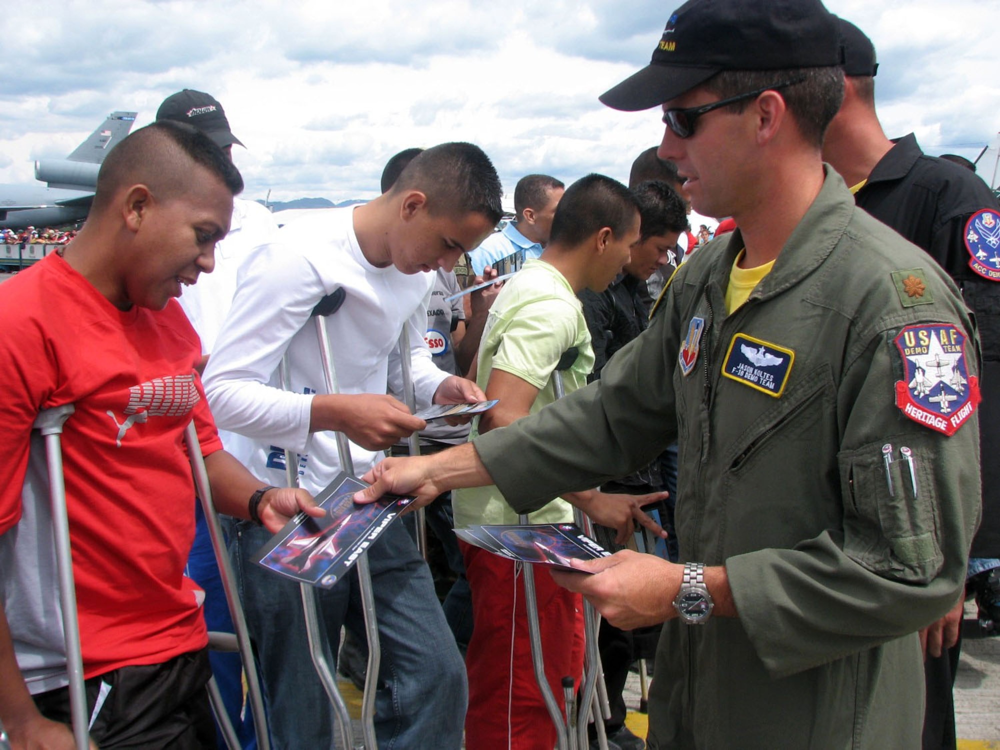 Maj. Jason Koltes hands out mementos to injured Columbian military veterans on Sunday, July 2. Major Koltes is the commander and a pilot for the F-16 Fighting Falcon Viper East aerial demonstration team. The team was in Colombia for the Rio Negro air show. (U.S. Air Force photo/1st Lt. Christina Mundy) 
