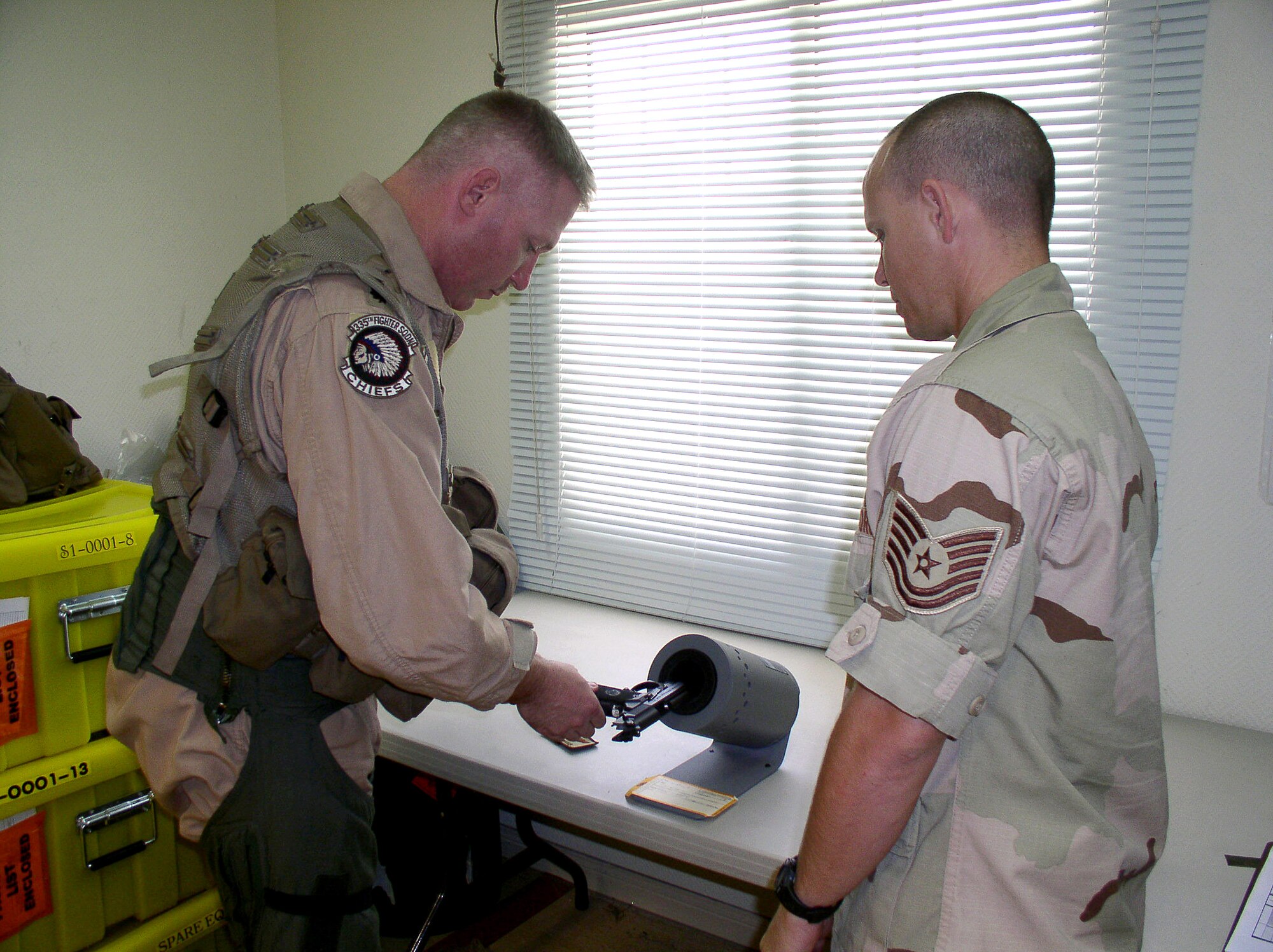 Life support specialist Tech. Sgt. Theodore Angel watches as Lt. Col. Mark Wiser, an F-15 Eagle pilot, loads his M-9 pistol before leaving for a combat mission on Saturday, July 1. Colonel Wiser and Sergeant Angel are deployed to the 335th Expeditionary Fighter Squadron in Southwest Asia from Seymour Johnson Air Force Base, N.C. (U.S. Air Force photo/Master Sgt. Dutch DeGroot)