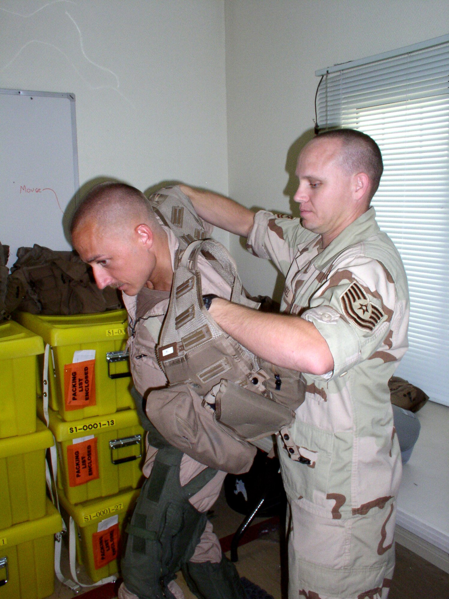 Life support specialist Tech. Sgt. Theodore Angel assists Capt. Michael Shields, a weapons systems officer, with his survival vest in preparation for a combat mission on Saturday, July 1. Captain Shields and Sergeant Angel are deployed to the 335th Expeditionary Fighter Squadron in Southwest Asia from Seymour Johnson Air Force Base, N.C. (U.S. Air Force photo/Master Sgt. Dutch DeGroot) 
