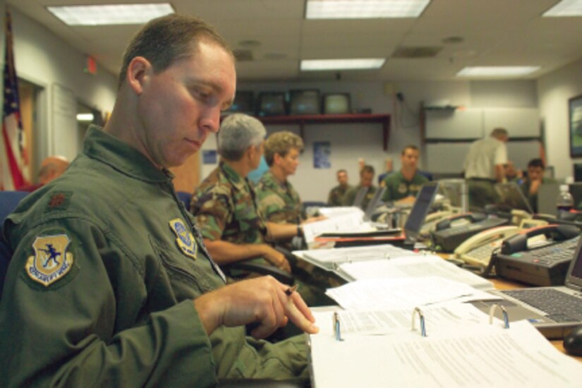 Maj. Roy Bacot, 437th Airlift Wing command post chief, goes over a HURCON3 checklist during a crisis action team meeting for the hurricane exercise Tuesday. 