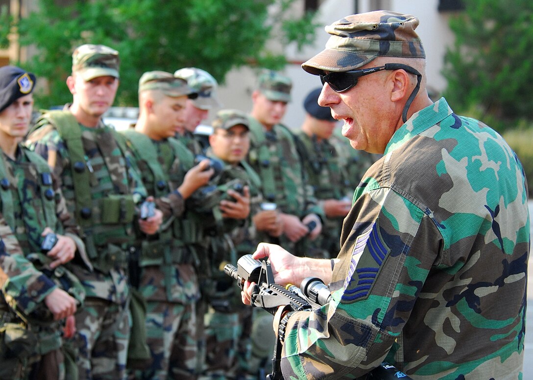 KIRTLAND AIR FORCE BASE, N.M. — Chief Master Sgt. Christopher Batta, 377th Security Forces Squadron here, demonstrates the proper installation of MILES equipment on a weapon during a two-part exercise here June 20. (Air Force photos by Todd Berenger)
