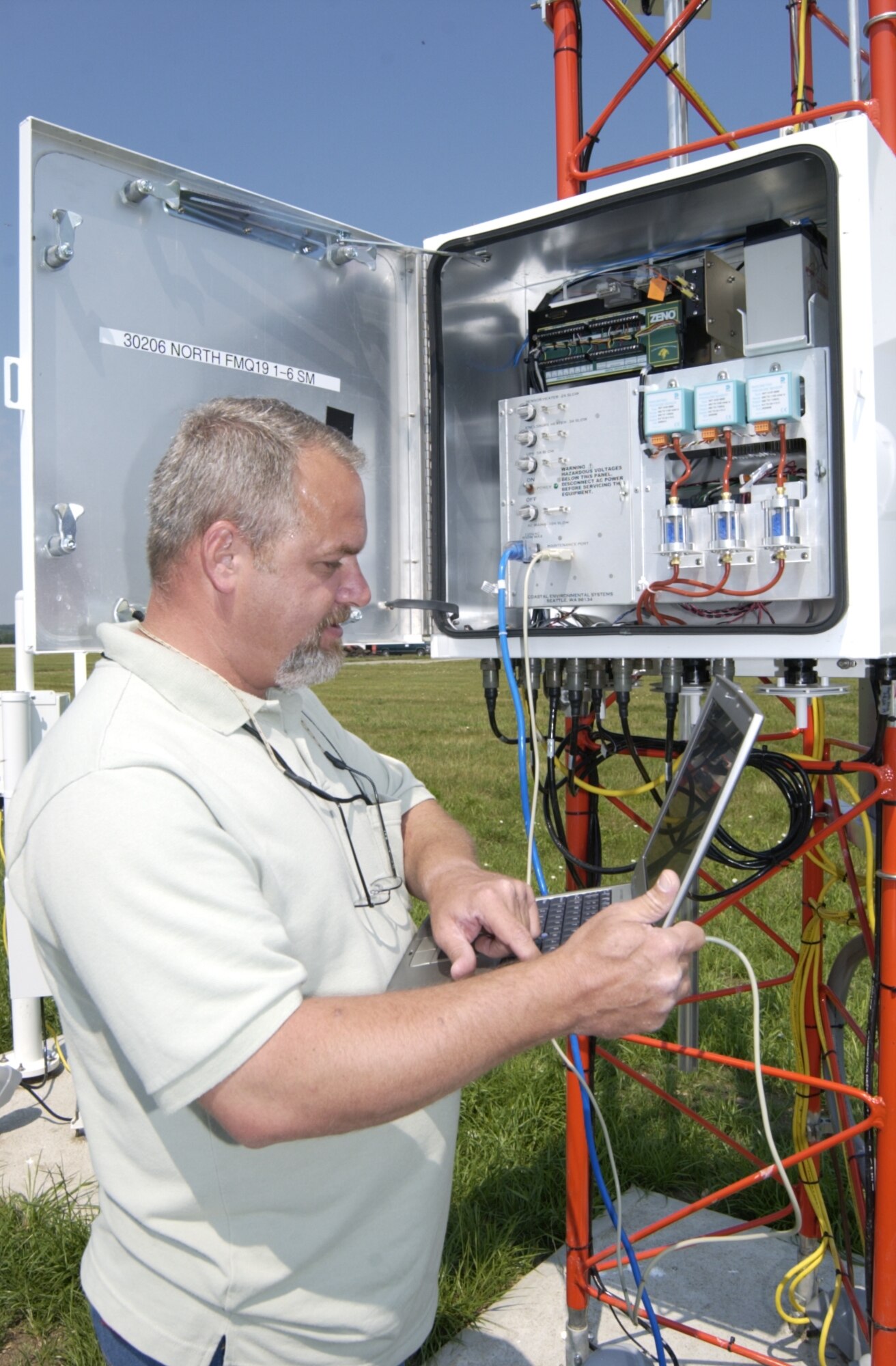 WRIGHT-PATTERSON AIR FORCE BASE, Ohio — Jim Raison, an electronics technician with the 88th Operations Support Squadron, uses a computer to run a diagnostic check of the FMQ-19 on the north end of the runway June 27. (Air Force photo by Spencer P. Lane)