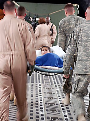 U.S. Air Force and Army medical personnel carry 8-year-old Omar Muhammad from an Air Force C-17 Globemaster July 2 after an Air Force aircrew flew him from America where the boy underwent life-saving heart surgery.  U.S. Army doctors at Forward Operating Base Salerno diagnosed the boy and arranged for his surgery in the U.S.  (US Air Force photo/Maj. David Kurle)
