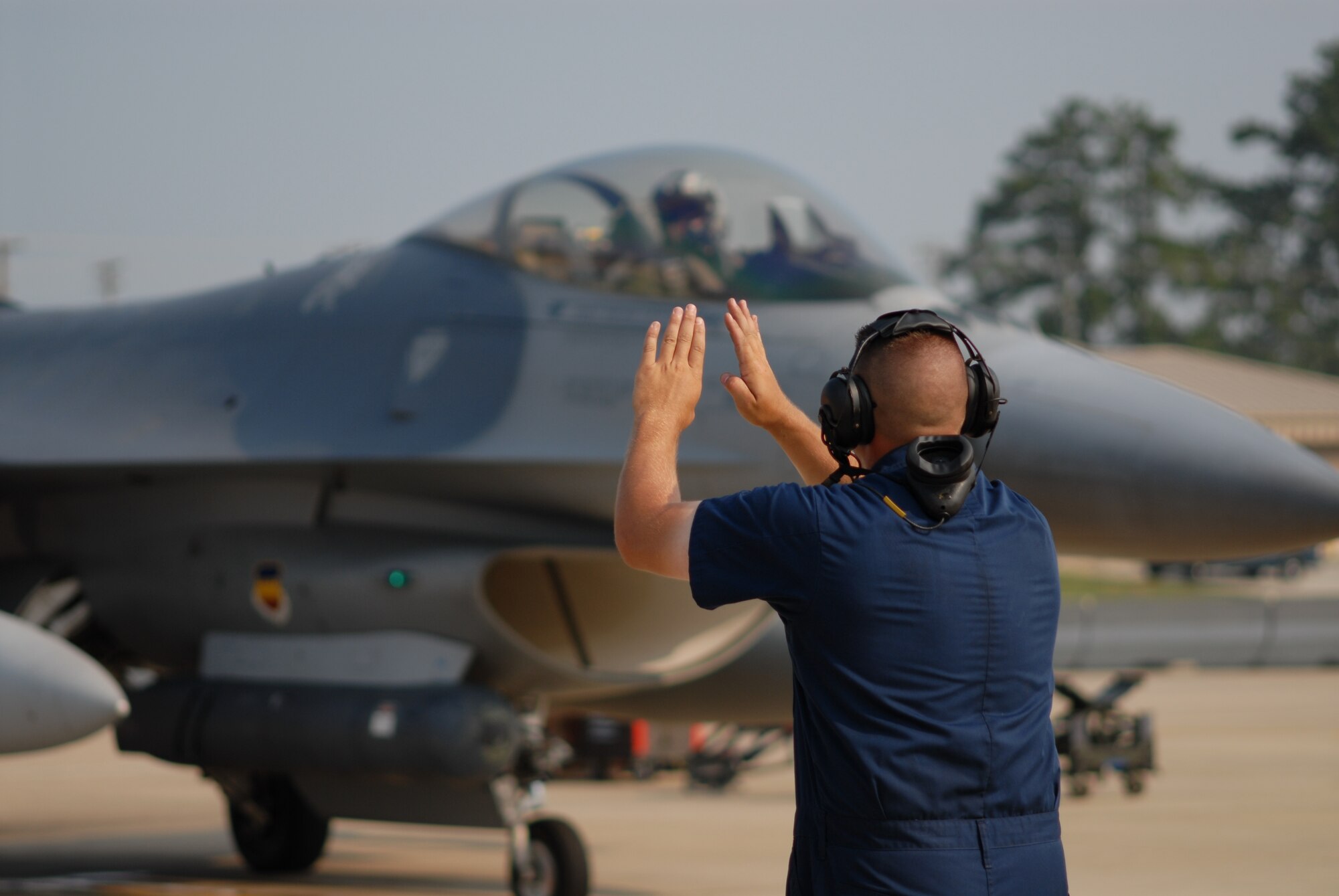 SSgt Brian Gaylor, 77th Fighter Squadron crew chief, marshalls an F-16 in support of Operation DYNAMIC WEASEL June 29, 2006 at Shaw AFB, South Carolina. Operation DYNAMIC WEASEL is a multi-aircraft exercise imitating combat operations currently taking place in Southeast Asia. (U.S. Air Force Photo/Tech. Sgt. James Arrowood) 