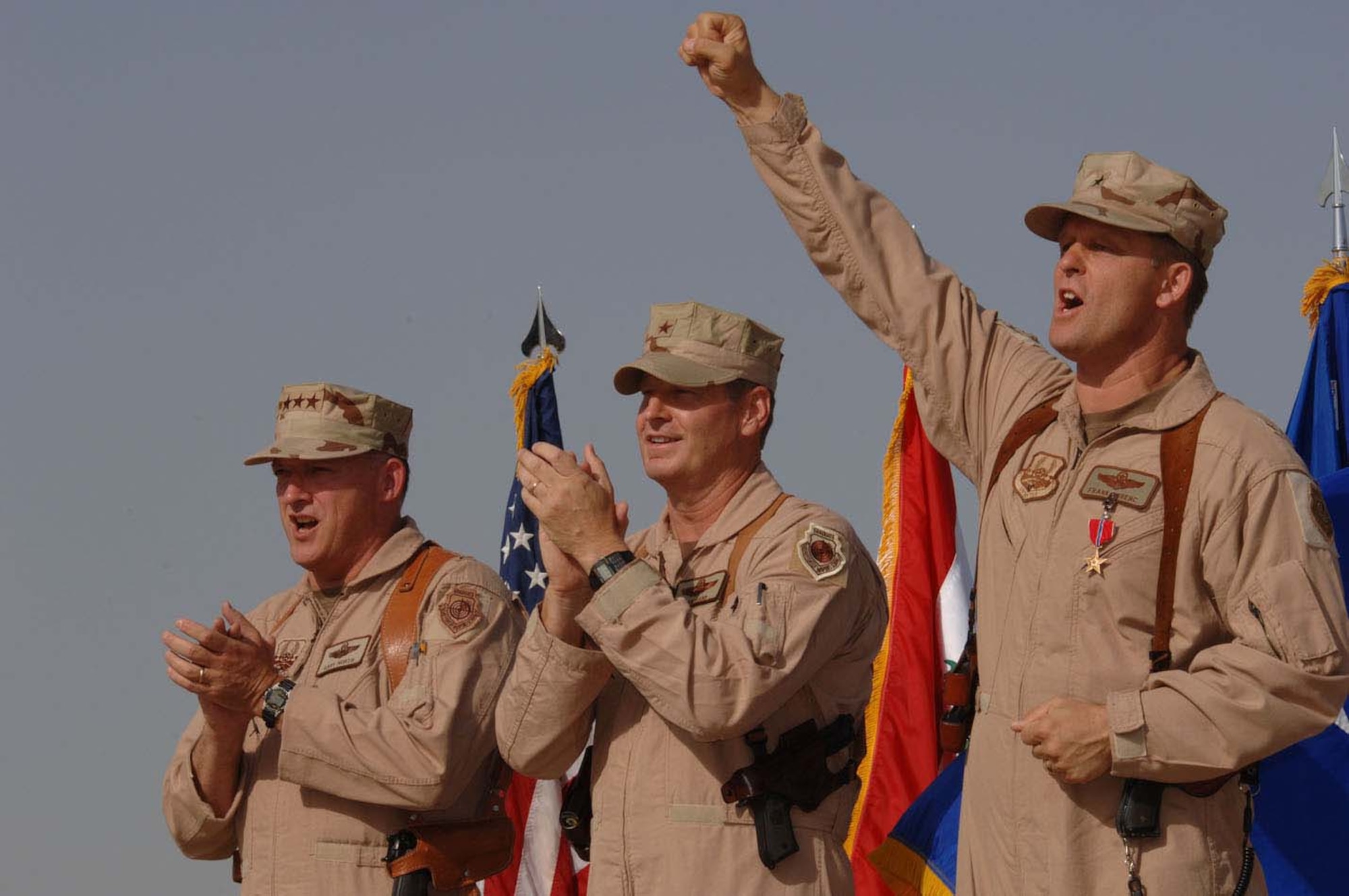 BALAD AIR BASE, Iraq -- "Give 'er the gun," shouts Brig. Gen. Frank Gorenc with his fist in the air while singing the Air Force song during the wing change of command ceremony here, July 5.  Lt. Gen. Gary North, U.S. Central Command Air Forces commander (left) officiated the passing of the 332d Air Expeditionary Wing flag to Brig. Gen. Robin Rand and announced that General Gorenc received the Moller Award as the most outstanding commander in Air Combat Command for his year of service in Iraq.  (U.S. Air Force photo by Staff Sgt. Tony Tolley) 