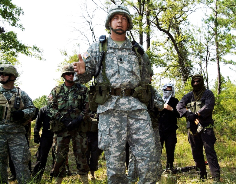 Army Lt. Col. Mike Kozlik briefs trainees on detecting improvised explosive devices during "in-lieu-of" training at Camp Shelby, Miss. The training incorporates lessons learned from several deployed locations as well as role-playing opposition forces. The colonel is the commander of the 3rd Battalion, 349th Infantry. (U.S. Air Force photo/Herb Welch)