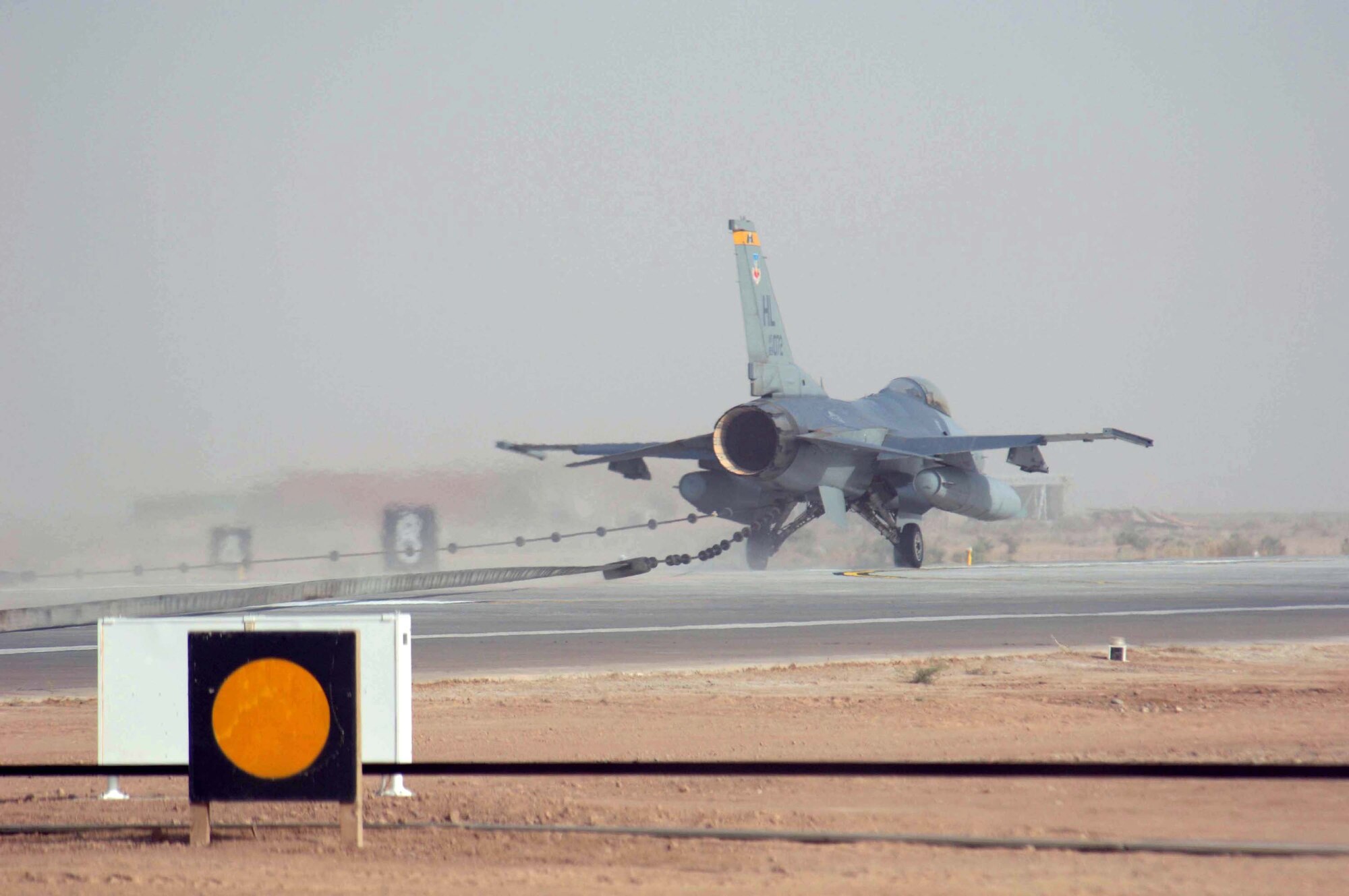 An F-16 Fighting Falcon tests the new aircraft arresting barrier at the end of the runway at Balad Air Base, Iraq, on Tuesday, July 4. The new barrier is expected to increase safety by catching aircraft before they roll off the end of the runway. (U.S. Air Force photo/Staff Sgt. Tony Tolley)