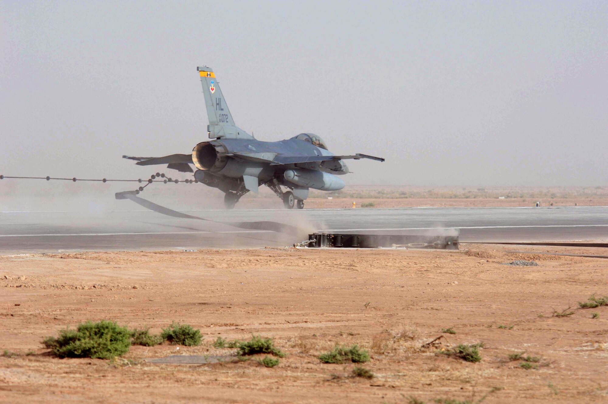 An F-16 Fighting Falcon tests the new aircraft arresting barrier at the end of the runway at Balad Air Base, Iraq, on Tuesday, July 4. The new barrier is expected to increase safety by catching aircraft before they roll off the end of the runway. (U.S. Air Force photo/Staff Sgt. Tony Tolley)