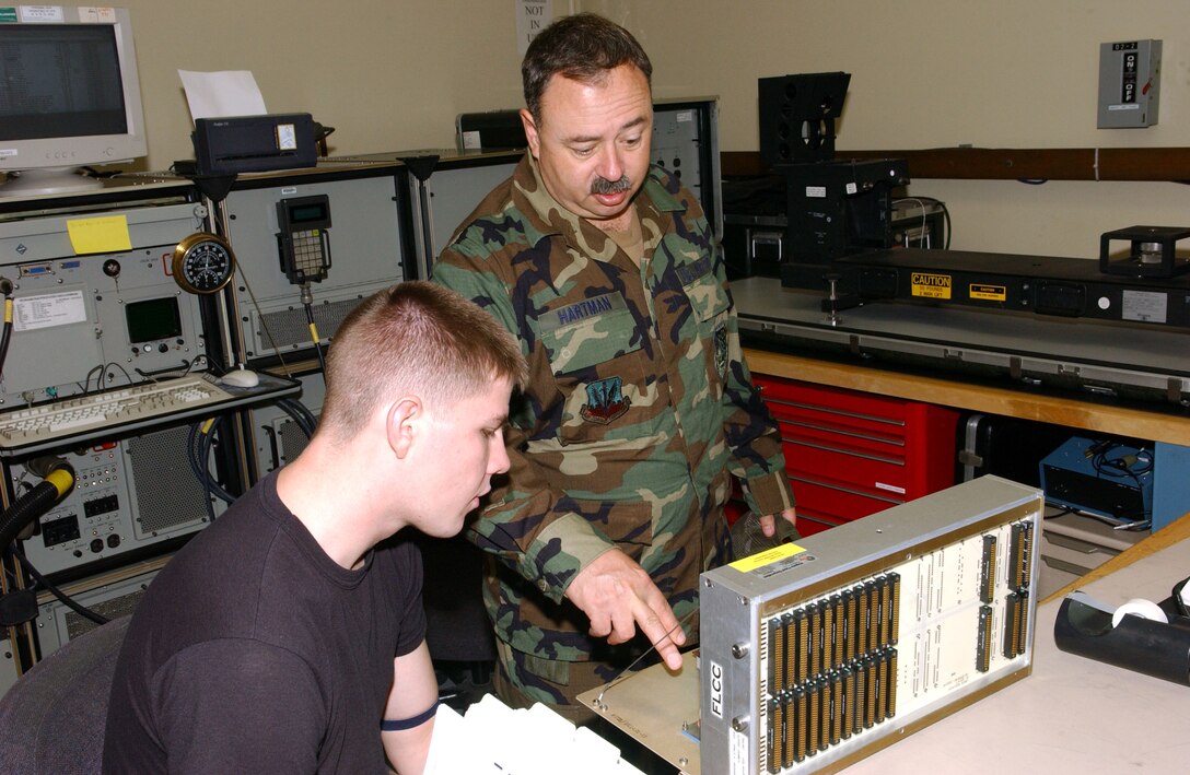 Senior Master Sgt. Gary Hartman (standing) troubleshoots a flight control computer with Senior Airman Lee Hammes at Kunsan Air Base, South Korea, on Thursday, July 6. Sergeant Hartman is with the Montana Air National Guard's 120th Fighter Wing. Airman Hammes is with Kunsan's 8th Maintenance Squadron. (U.S. Air Force photo/Tech. Sgt. Erik Gudmundson)
