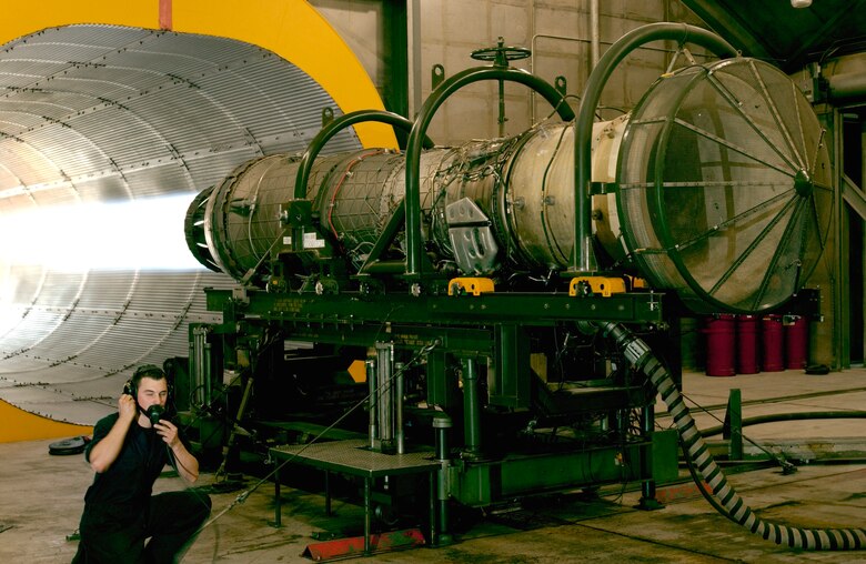 Senior Airman Charles Scaperotto, 57th Component Maintenance Squadron aerospace propulsion mechanic, relays information to his co-workers in the control cab during a full afterburner test of an engine that powers an F-16 Fighting Falcon. Nellis Air Force Base, Nev., has two engine Hush Houses that significantly reduce the amount of engine noise heard on and off the base during test runs. (U.S Air Force Photo/Staff Sgt. Darryl Barnes)