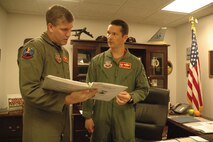 MINOT AIR FORCE BASE, N.D. -- Lt. Col. Jerry Hounchell, (right) 23rd Bomb Squadron commander, goes over the daily flight schedule with Capt. Scott Axelson, 23rd BS, at the PRIDE building Wednesday. Colonel Hounchell assumed command June 23.  (U.S. Air Force photo by Senior Airman Danny Monahan)