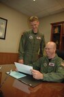 MINOT AIR FORCE BASE, N.D. -- Lt. Col. Don Conley, (left) 91st Operations Support Squadron commander, looks over a package to standardize duty titles within the 91st OSS with Capt. Neal Roach, 91st OSS, at the 91st Space Wing headquarters building Wednesday. Colonel  Conley assumed his new command June 21. (U.S. Air Force photo by Senior Airman Danny Monahan)
