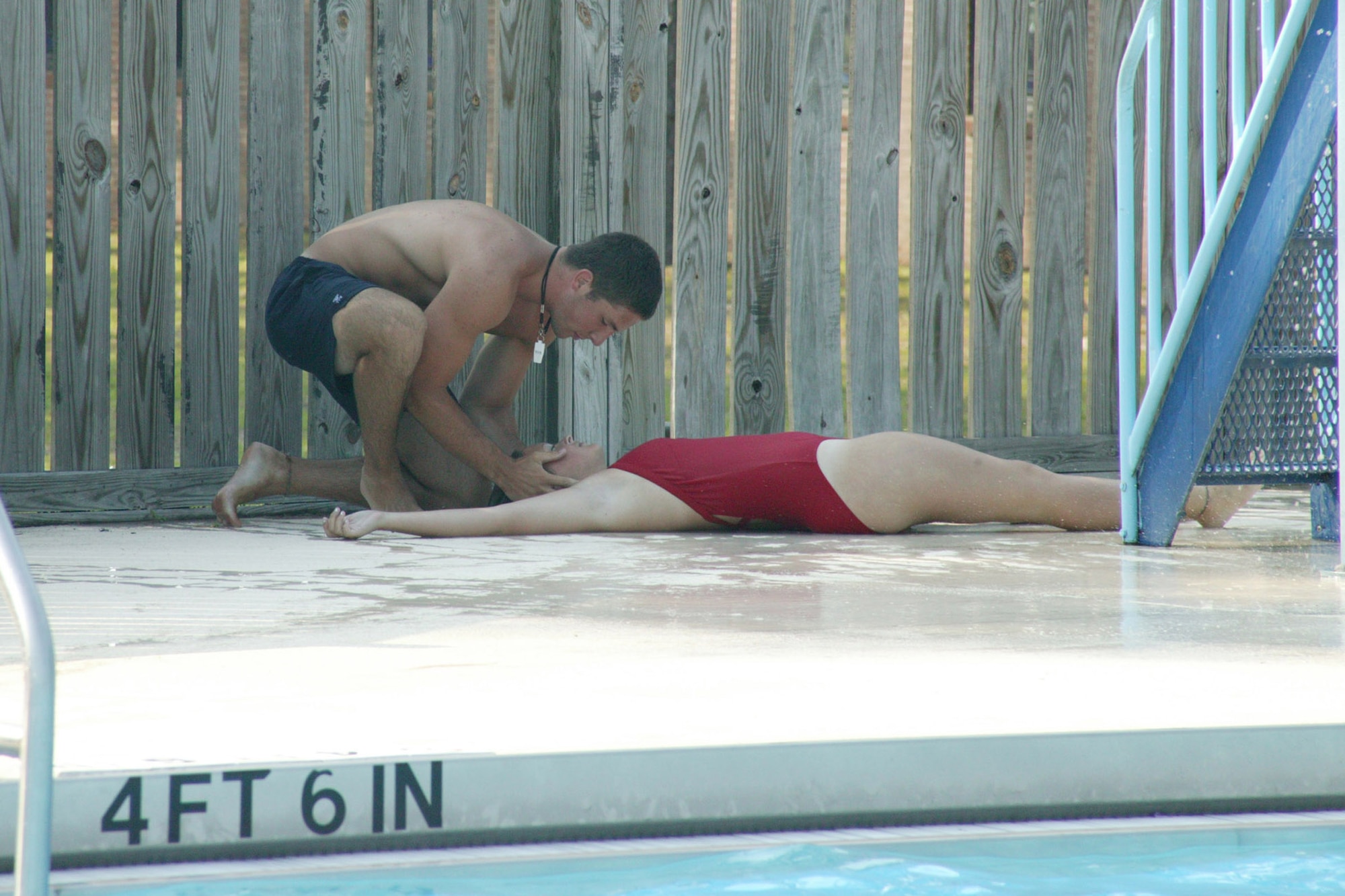 Garrett Williamson, 20th Services Squadron lifeguard, stabilizes the neck of a simulated fall victim, fellow lifeguard Tiffany Rogers, to prevent any additional injuries following her simulated fall off of the pool's waterslide. (U.S. Air Force photo/Tarsha Storey)