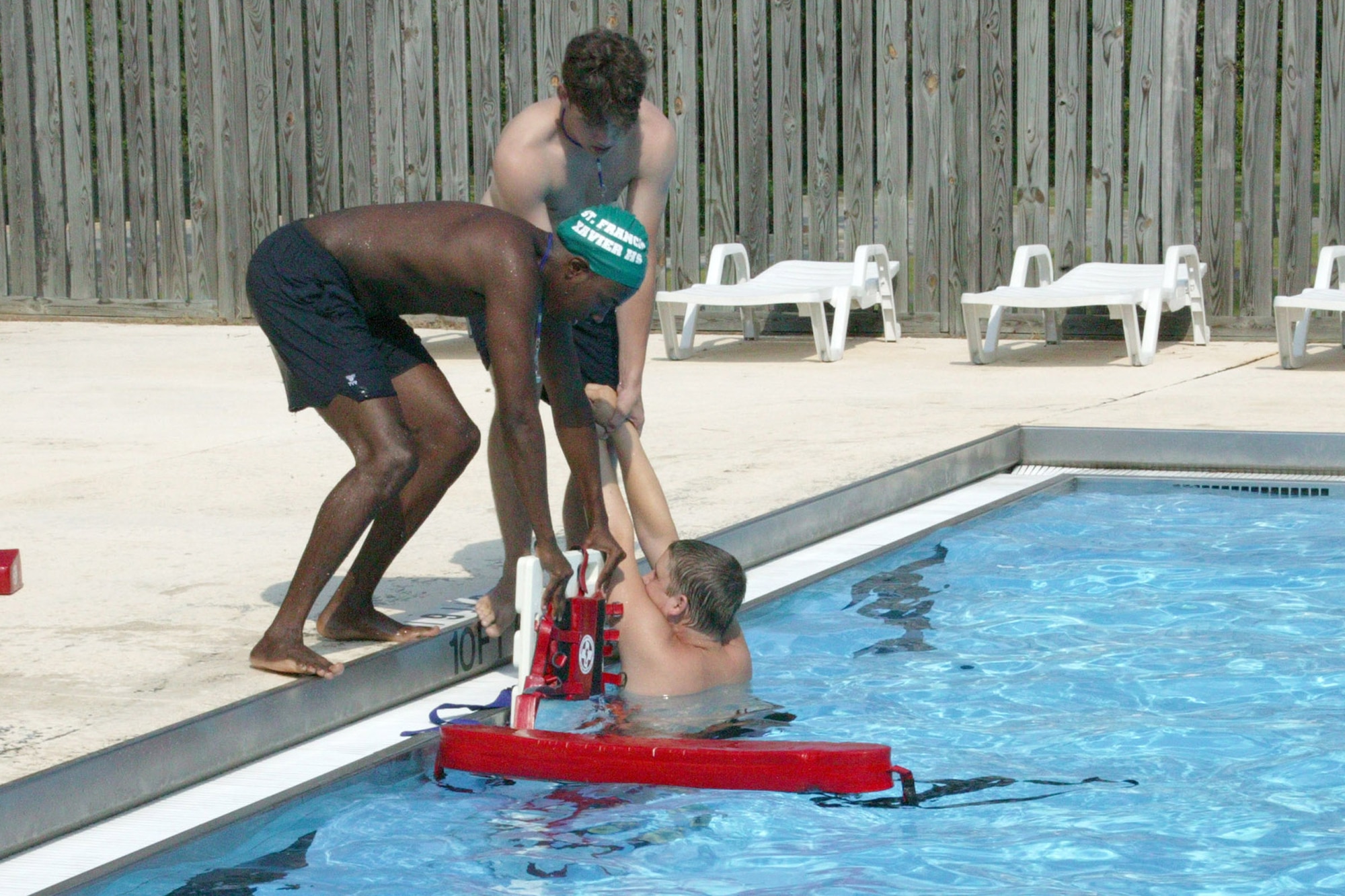 Josh Hallums (left) and Phillip Farmer, both 20th Services Squadron lifeguards, "rescue" fellow lifeguard Cody Wells, a simulated drowning victim, during a recent lifeguard training exercise. (U.S. Air Force photo/Tarsha Storey)
