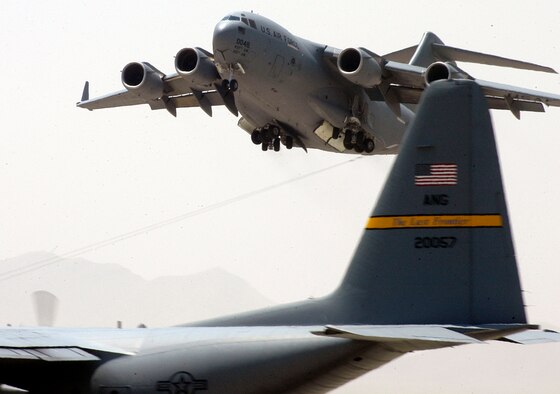 A C-17 Globemaster III from Charleston Air Force Base, S.C., takes off from Bagram Air Base, Afghanistan, on Tuesday, July 4, while a C-130 Hercules from the Alaska Air National Guard waits to take the runway. Strategic and tactical airlift are the backbone of the logistics efforts for Operation Enduring Freedom in Afghanistan. (U.S. Air Force photo/Maj. David Kurle) 