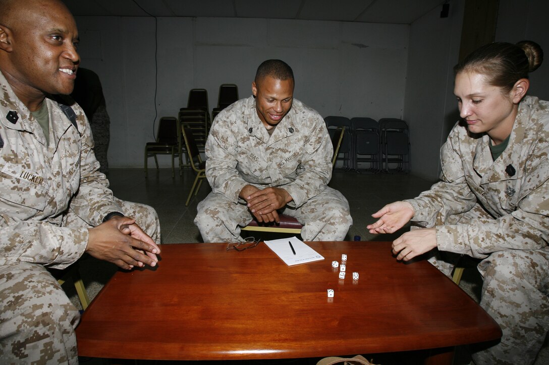 (From left to right) Master Gunnery Sgt. Ralph L. Tucker, from Rice, Va.; Staff Sgt. Jeff S. Bias, from Columbus, Ohio; and Petty Officer Second Class Katheryn D. Nuzum, from Stanton, Iowa, enjoy some jazz music and each other's company while shooting craps at Camp Taqaddum, Iraq July 7, 2006. The jazz night's inauguration a few weeks ago filled a niche for Marines who did not attend other recreational activities such as the videogame room, which are geared more towards younger Marines. Jazz night at the recreation center here may not have the same atmosphere found in one of its New York or Chicago counterparts, but it serves its purpose for the Marines, sailors and soldiers stationed at this logistics hub located in the heart of the unpredictable Al Anbar Province. Official USMC photo by: Sgt. Enrique S. Diaz (060707-M-2864D-002) (Released)