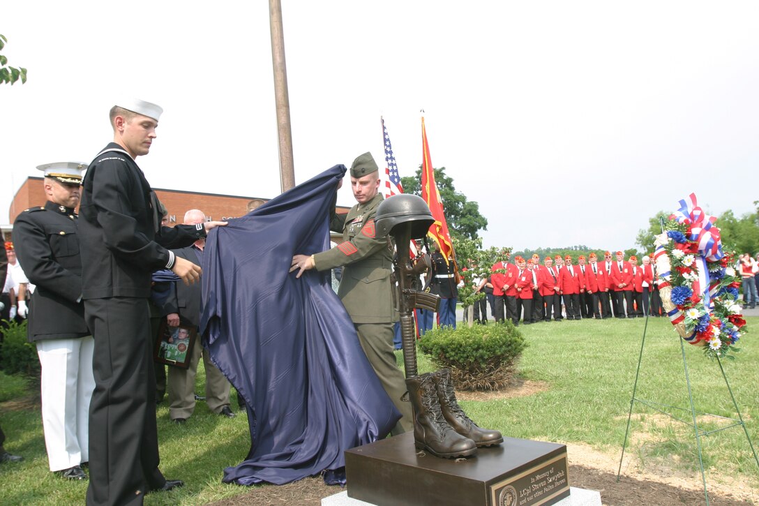 Petty Officer 3rd Class Tim Licouture, hospital corpsman, Weapons Company, Battalion Landing Team, 2nd Bn., 2nd Marine Regiment, and Staff Sgt. Wayne T. Byron, platoon sergeant, 81mm Mortar Platoon, Weapons Co., Battalion Landing Team, 2nd Bn., 2nd Marines, unveil a memorial statue on the grounds of South Fulton High School in Warfordsburg, Penn., July 9, 2006.  The inscription on the statue's base reads:  "In Memory of LCpl Steven Szwydek and our other Fallen Heroes."
